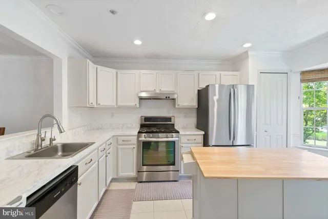 a kitchen with kitchen island granite countertop a stove cabinets and sink