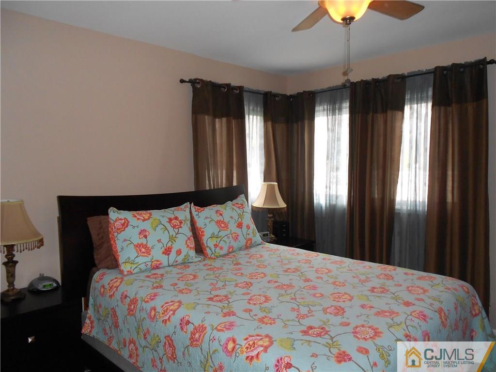 29 Kendall Road Kendall Park, NJ 08824 - Photo 13 of 22 a bedroom with a bed and a chandelier