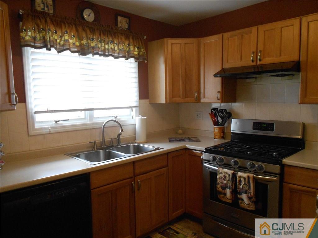 29 Kendall Road Kendall Park, NJ 08824 - Photo 5 of 22 a kitchen with granite countertop a sink a stove and a microwave