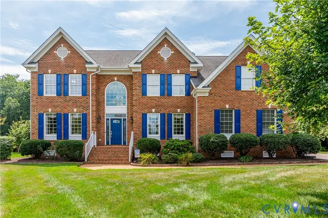 a large kitchen with stainless steel appliances granite countertop wooden floors wooden cabinets a window and a sink