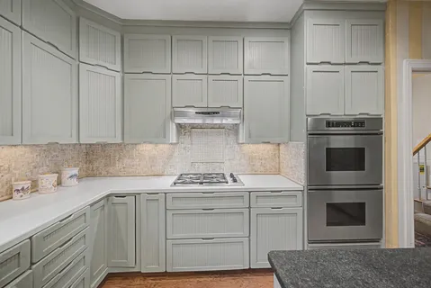 a kitchen with a sink cabinets and wooden floor