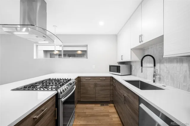a view of wooden floor fire place and windows in a room
