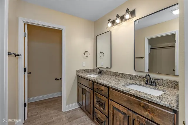 a bathroom with a granite countertop sink double vanity and a mirror