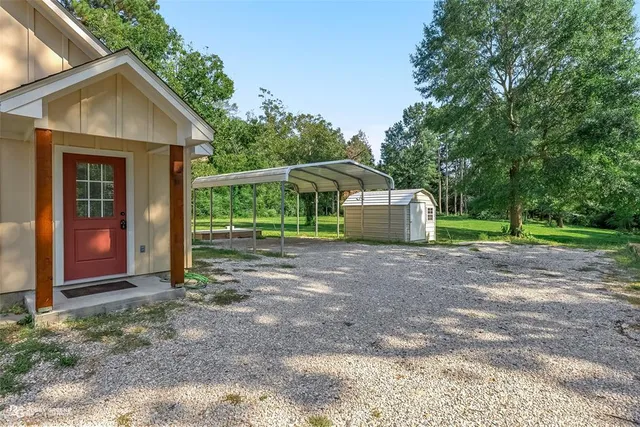 a view of a house with backyard and trees
