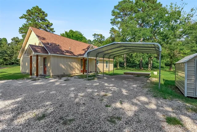 a view of a house with backyard and a tree