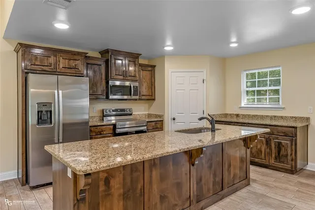 a kitchen with stainless steel appliances granite countertop a sink stove and refrigerator