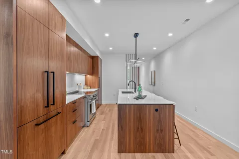 a kitchen with stainless steel appliances a sink a table and chairs