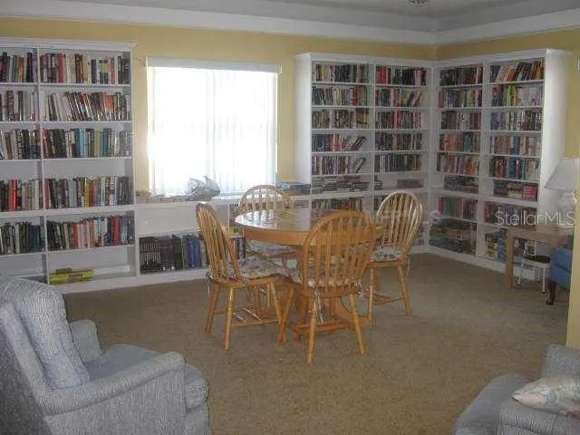a view of a dining room with furniture a rug and wooden floor