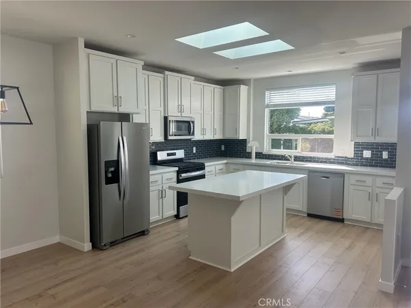 a kitchen with a refrigerator a sink dishwasher stove and refrigerator