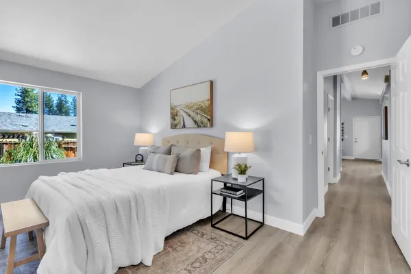a bedroom with a bed and a painting on the wall