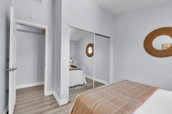 a bedroom with a bed and a painting on the wall