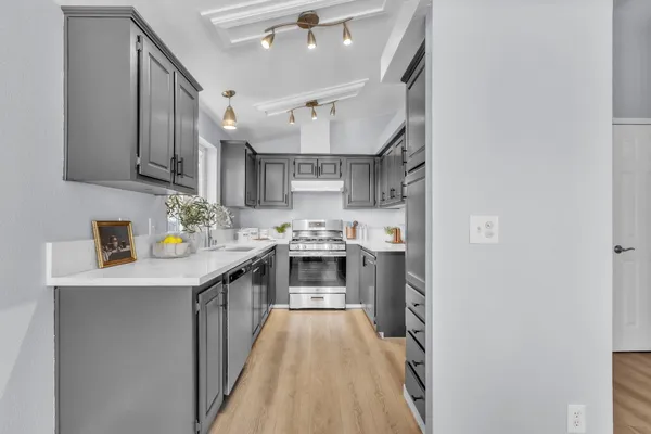 a kitchen with stainless steel appliances a stove refrigerator sink and cabinets