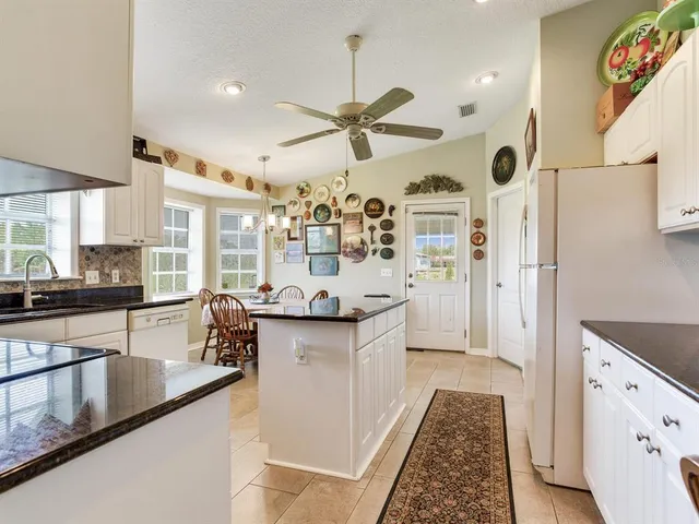 a kitchen with granite countertop white cabinets and window