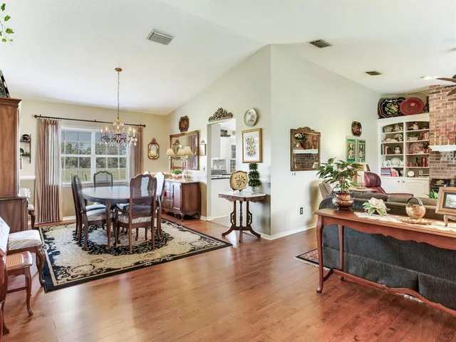 a dining room with furniture a chandelier and wooden floor