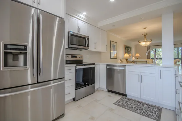 a kitchen with white cabinets and stainless steel appliances