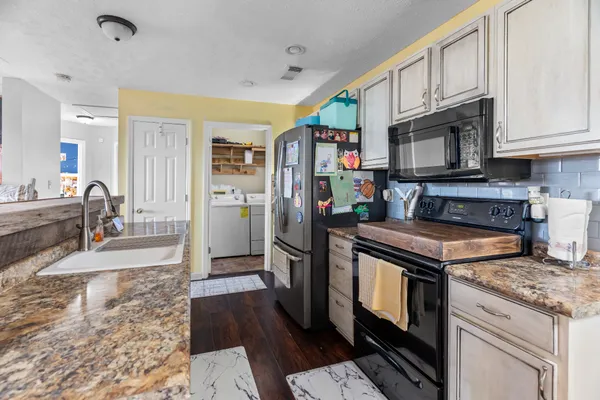 a kitchen with stainless steel appliances granite countertop a stove refrigerator and cabinets