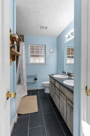 a bathroom with a sink toilet and window