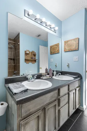 a bathroom with a granite countertop sink a toilet and mirror