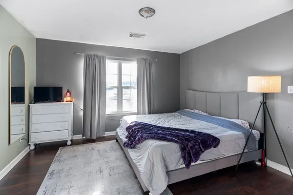 a bedroom with a bed a table and flat screen tv