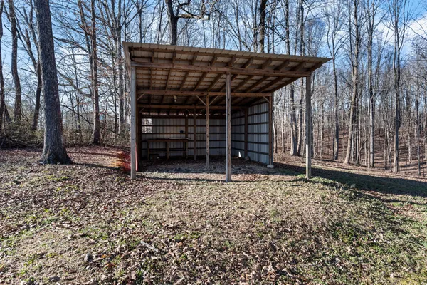 a view of a wooden house with a large window and wooden fence
