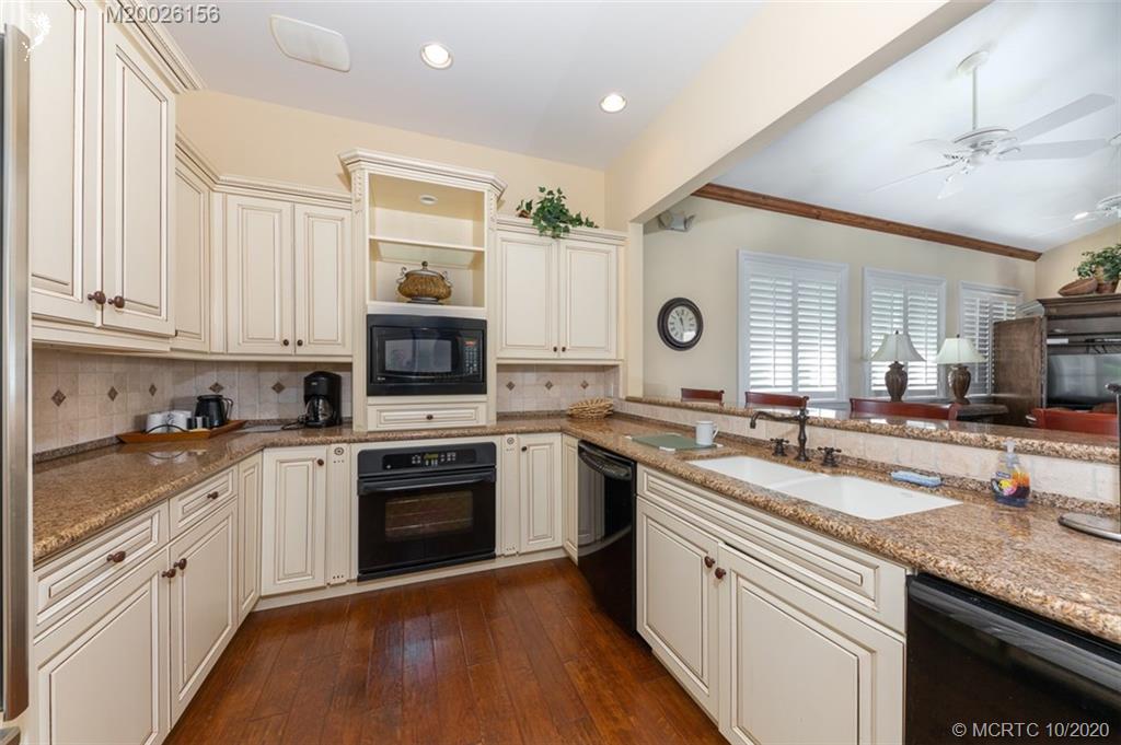 982 Southeast Willoughby Trace, Unit 15 Stuart, FL 34997 - Photo 34 of 36 a kitchen with granite countertop a sink stainless steel appliances and cabinets