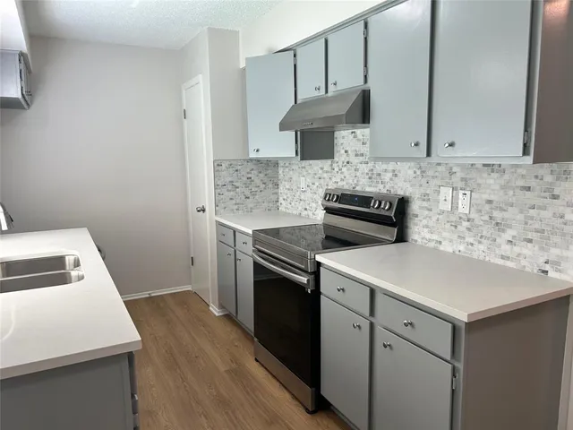 a kitchen with a sink stove and cabinets
