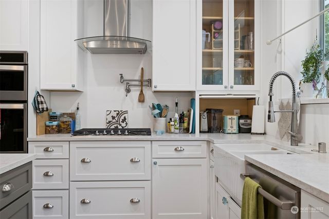 a kitchen with cabinets stainless steel appliances and a sink