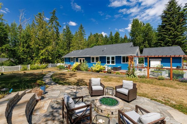 a view of swimming pool with lawn chairs and plants