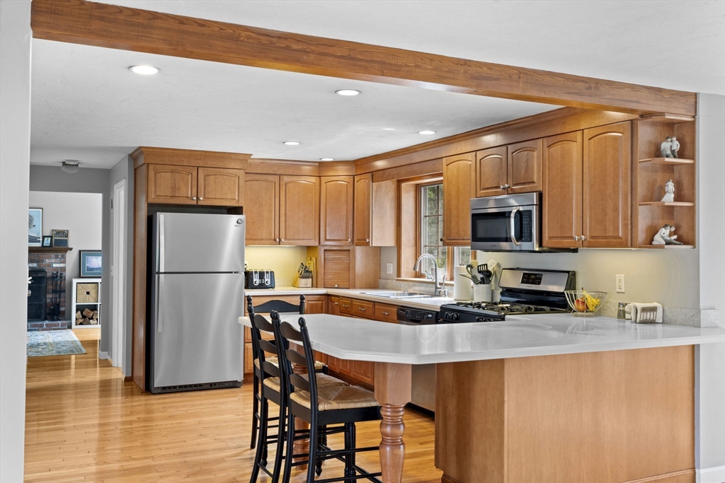 3 Marion Road Scituate, MA 02066 - Photo 8 of 30 a kitchen with stainless steel appliances granite countertop a refrigerator a stove a sink a dining table and chairs with wooden floor