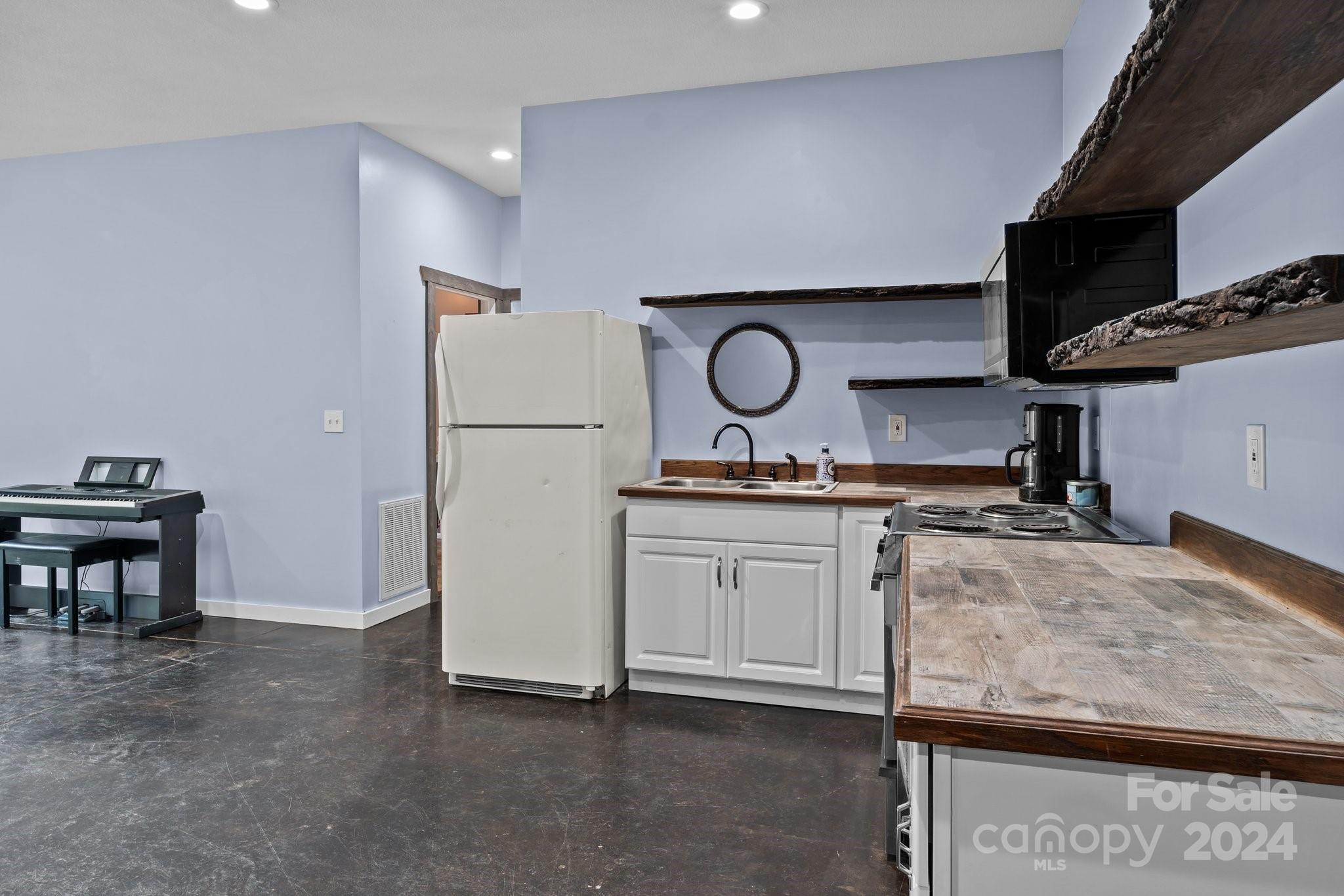 3500 Silver Creek Road Mill Spring, NC 28756 - Photo 14 of 42 a kitchen with a refrigerator and a stove top oven