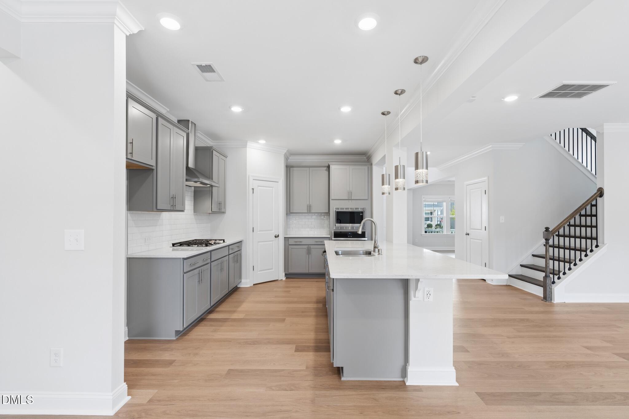2616 Nordmann Fir Road Raleigh, NC 27616 - Photo 17 of 53 a large kitchen with stainless steel appliances kitchen island wooden floors and white cabinets