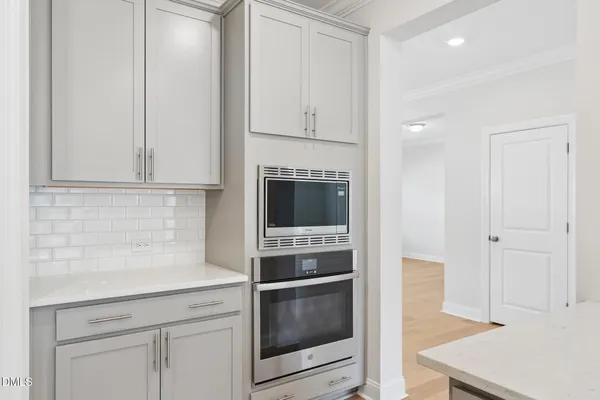a view of kitchen with stainless steel appliances sink refrigerator and wooden floor