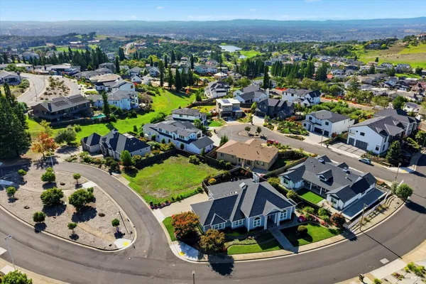 an aerial view of a house with a garden and mountain view in back