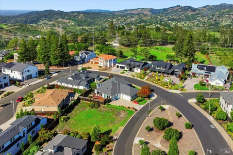 an aerial view of a house with a swimming pool yard and mountain view in back