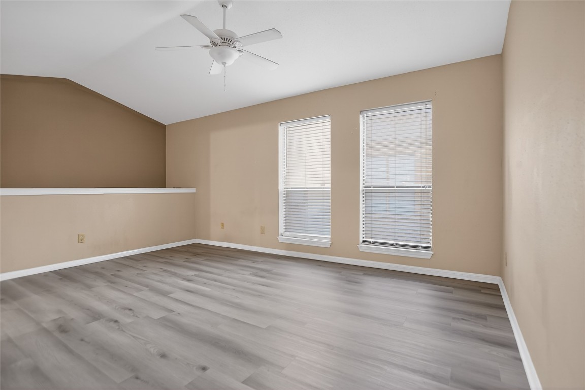 8299 Cambridge Street, Unit 706 Houston, TX 77054 - Photo 16 of 30 an empty room with wooden floor chandelier fan and windows