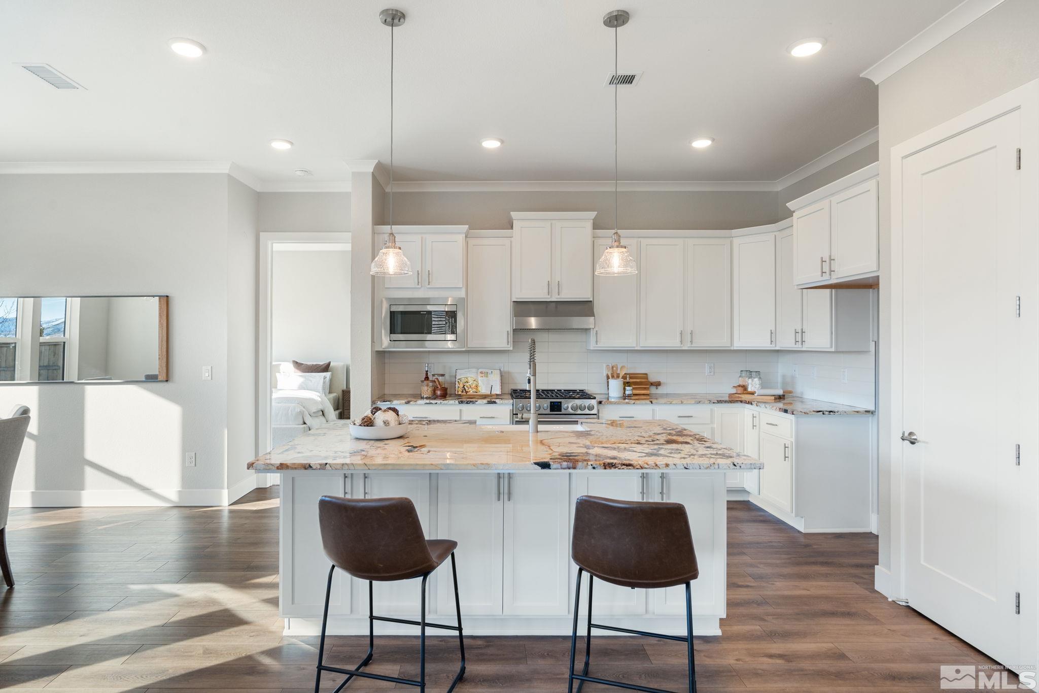 1621 Huntley Trail Reno, NV 89523 - Photo 14 of 40 a kitchen with stainless steel appliances granite countertop a stove a sink a oven a dining table and chairs with wooden floor