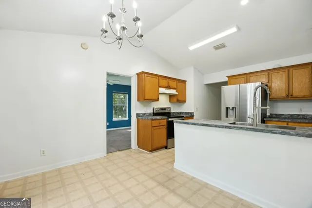 a kitchen with stainless steel appliances a refrigerator and a stove top oven