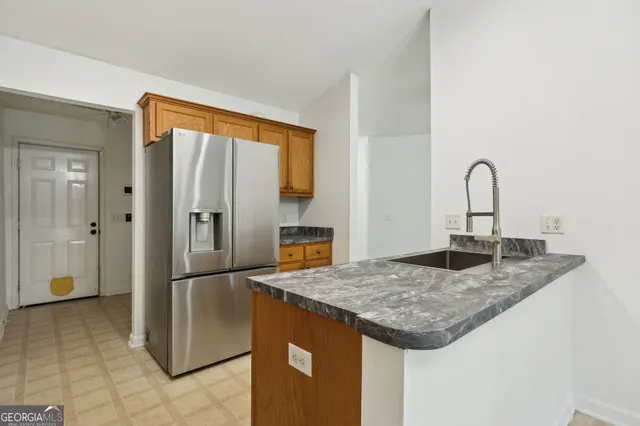 a kitchen with a granite countertop refrigerator and cabinets