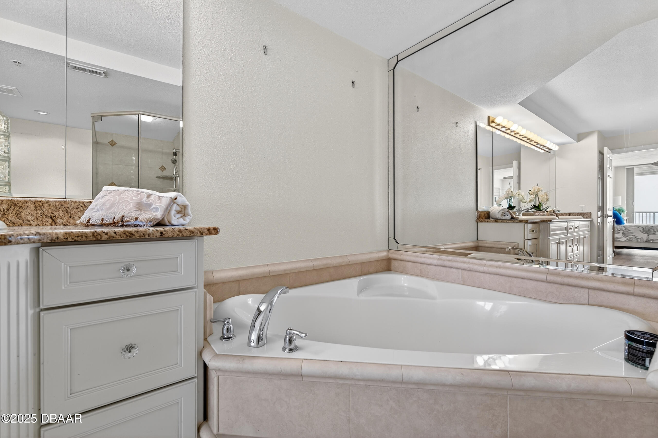 4555 South Atlantic Avenue, Unit 4603 Ponce Inlet, FL 32127 - Photo 31 of 39 a bathroom with a tub a sink and mirror
