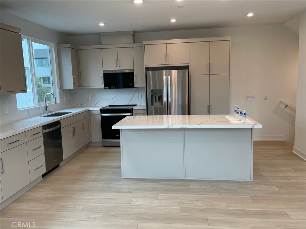 691 South Lyon Street Santa Ana, CA 92705 - Photo 5 of 17 a kitchen with kitchen island granite countertop a stove and a sink
