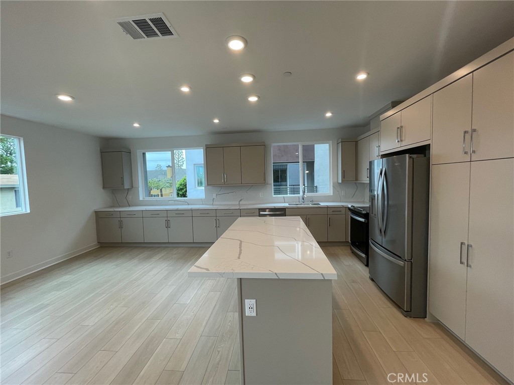 691 South Lyon Street Santa Ana, CA 92705 - Photo 10 of 17 a kitchen with kitchen island a counter top space stainless steel appliances and a window