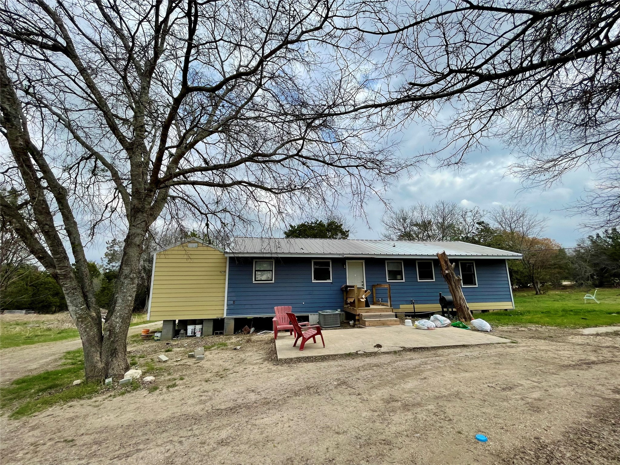 893 County Road 3376 Kempner, TX 76539 - Photo 1 of 23 a view of a house with large trees and a table and chairs under an umbrella
