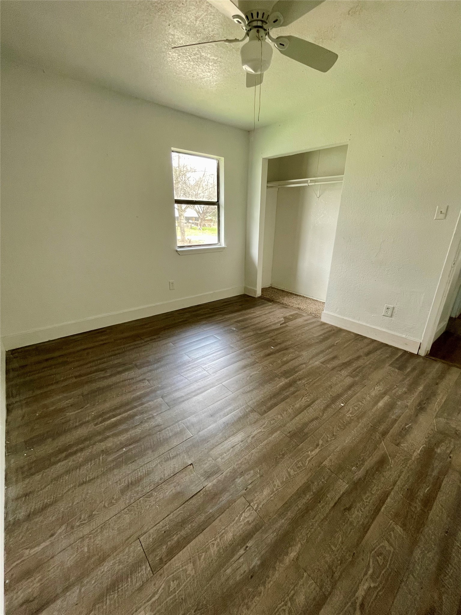 893 County Road 3376 Kempner, TX 76539 - Photo 12 of 23 an empty room with wooden floor fan and windows
