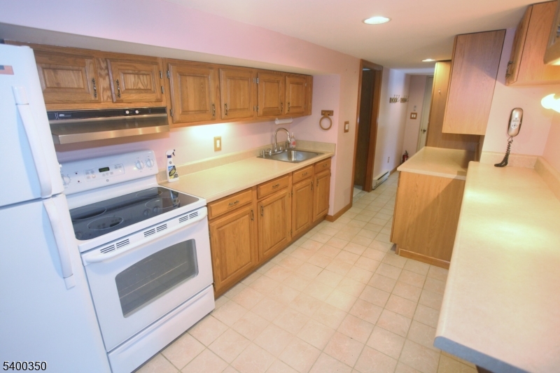 22 Choctaw Oak Ridge Oak Ridge, NJ 07438 - Photo 14 of 23 a kitchen with a stove a sink and a refrigerator