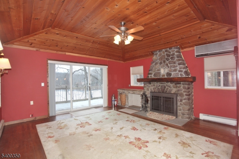 22 Choctaw Oak Ridge Oak Ridge, NJ 07438 - Photo 2 of 23 a view of a livingroom with a fireplace a ceiling fan and wooden floor