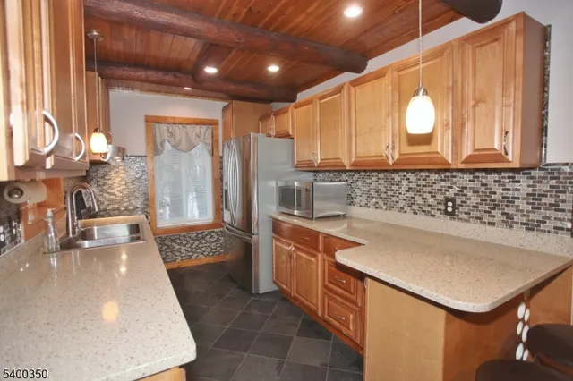 a kitchen with stainless steel appliances granite countertop a sink a stove and a refrigerator
