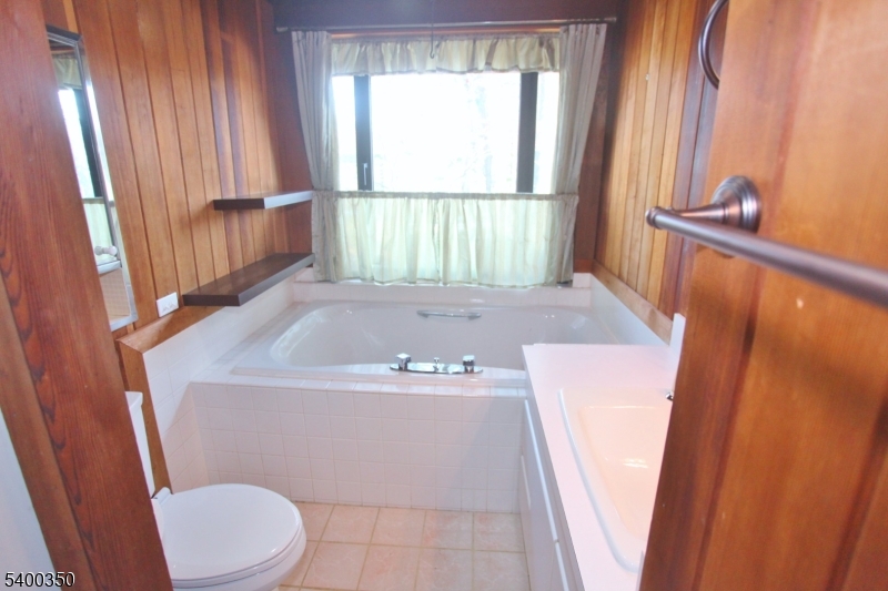 22 Choctaw Oak Ridge Oak Ridge, NJ 07438 - Photo 10 of 23 a bathroom with a sink a toilet a tub and a window