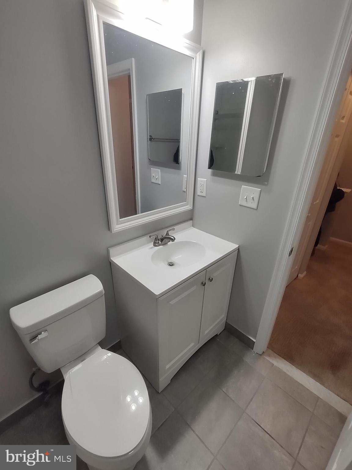 11235 Kettering Place Upper Marlboro, MD 20774 - Photo 11 of 22 a bathroom with a toilet sink and mirror