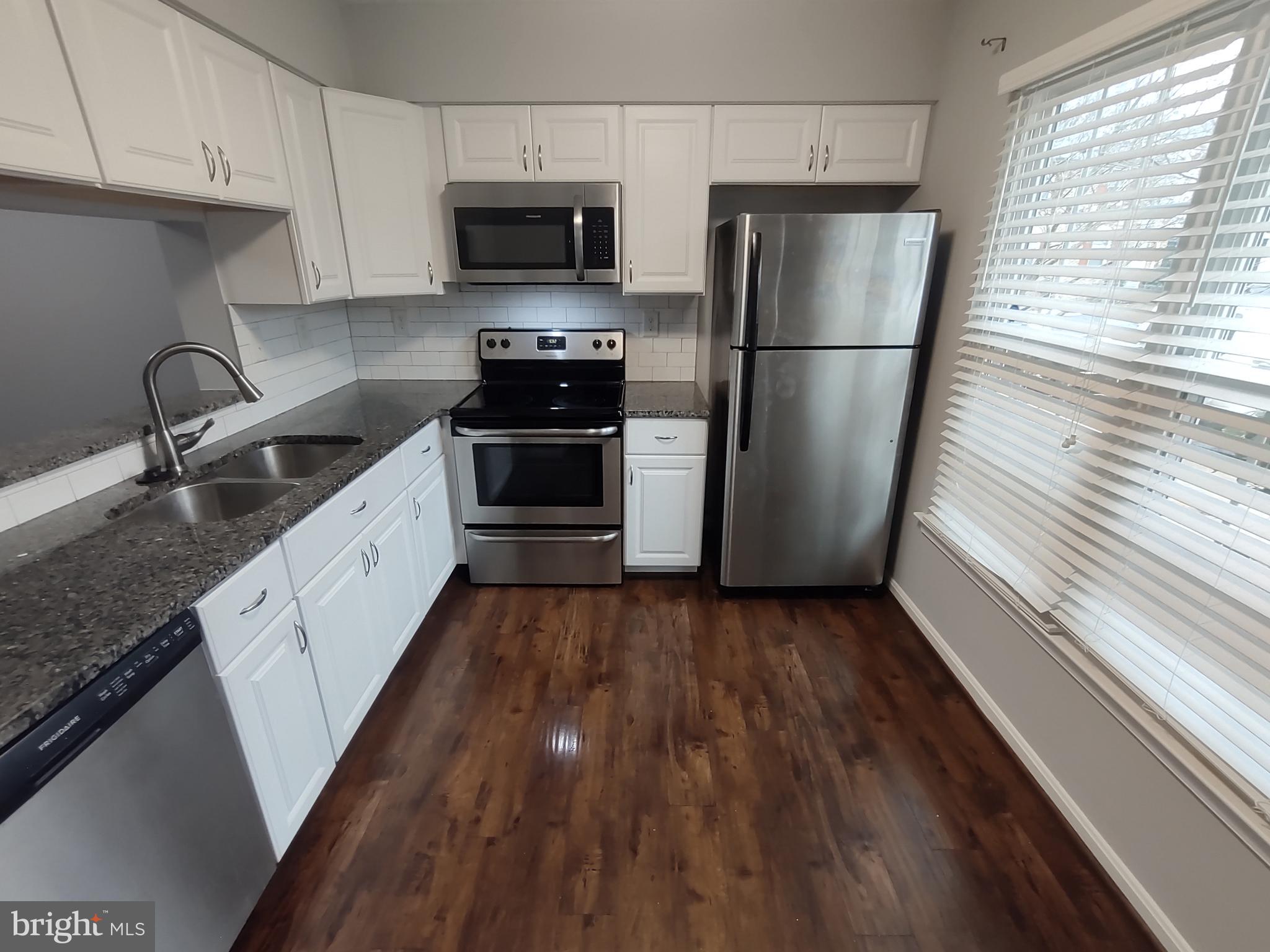 11235 Kettering Place Upper Marlboro, MD 20774 - Photo 19 of 22 a kitchen with a sink a refrigerator and a stove top oven