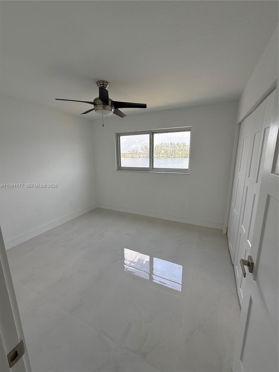 9915 West Okeechobee Road, Unit 2201 Hialeah Gardens, FL 33016 - Photo 8 of 11 an empty room with windows and fan